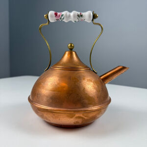 vintage copper tea kettle with a brass and ceramic white floral handle